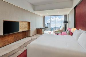 a hotel room with a large bed and a flat screen tv at Hilton Guangzhou Tianhe in Guangzhou