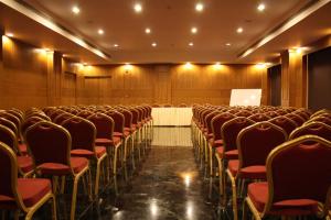 una sala de conferencias con sillas rojas y una mesa blanca en La Franklin Hotel, en Bhubaneshwar