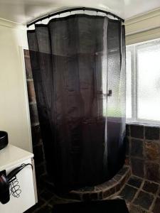 y baño con ducha con cortina negra. en The Lamu Suite, en Brisbane 25 fotos más