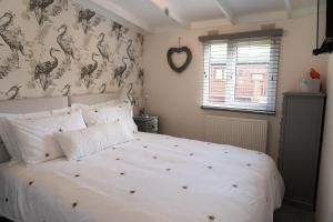 una camera da letto con un letto bianco e carta da parati ad uccello di Lakeview Lodge, Builth Wells no tradesmen allowed a Builth Wells