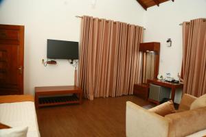 a living room with a couch and a flat screen tv at Adaviya Resort in Mahiyangana