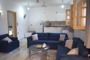 a living room with a blue couch and a table at AL Farida Guest House in Jazīrat al ‘Awwāmīyah