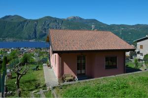 mały domek na wzgórzu z górami w tle w obiekcie Casa Virginia w mieście Mandello del Lario