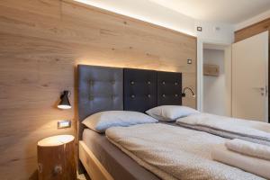 a bedroom with two beds with a large headboard at Molveno Bellavista - Lake in Molveno +41 photos