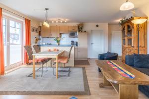 a living room with a table and a kitchen at Haus Undine Wohnung 09 in Boltenhagen