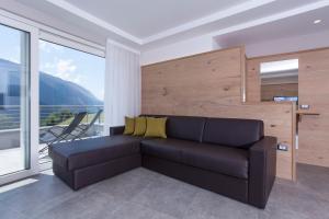 a living room with a couch and a large window at Molveno Bellavista - Lake in Molveno