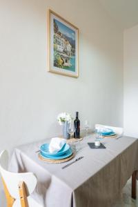 mesa de comedor con mantel blanco y platos azules en Exclusive Deluxe Apt Between DUOMO & SAN SIRO, en Milán