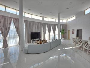 WāsiţEbreez lounge的配有沙发和电视的大客厅