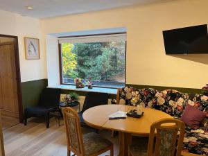 a living room with a table and a window at Pension Edlinger in Mallnitz