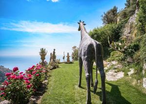 a statue of a giraffe standing in the grass at La Chèvre d'Or in Éze