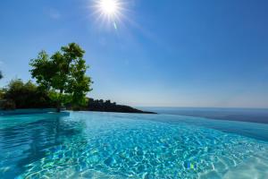 a swimming pool with a tree in the water at La Chèvre d'Or in Éze