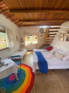 una sala de estar con dos camas y una mesa en Blue House Vale do Capão, en Palmeiras