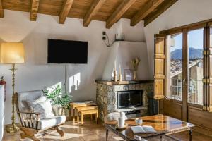 a living room with a fireplace and a tv at La Cabanya de la Rovira - Dalt in Joanetes