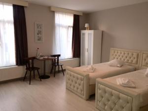 a hotel room with two beds and a table and a dining room at Prestige Flats in Brussels