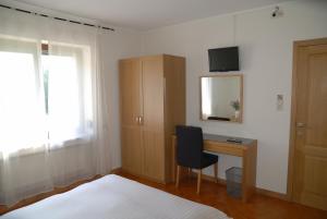 a bedroom with a bed and a desk with a chair at Guesthouse Les Tilleuls in Fleurus