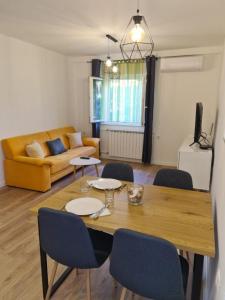 a living room with a table and chairs and a couch at Apartment Sani in Supetar