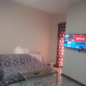 a living room with a couch and a flat screen tv at Sarker in Abu Dhabi