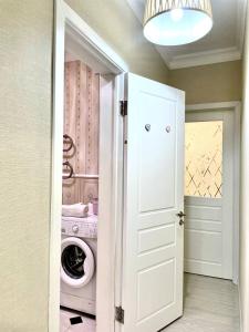 a laundry room with a washer and dryer at Promenade Expo in Prigorodnyy +5 photos