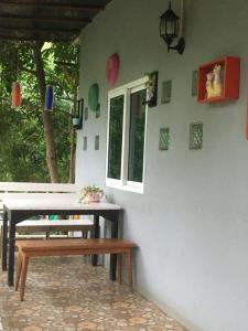 a table and a bench next to a wall at SlowLife Kohlarn in Ko Larn
