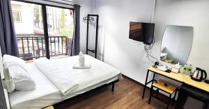ein Schlafzimmer mit einem Bett, einem Spiegel und einem Fernseher in der Unterkunft X GO INN Chiang Mai University - CMU โกอินน์ มหาวิทยาลัยเชียงใหม่ in Chiang Mai