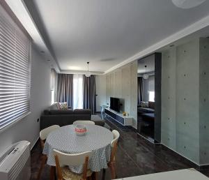 a living room with a table and a couch at Era Palace Apartments in Vlorë