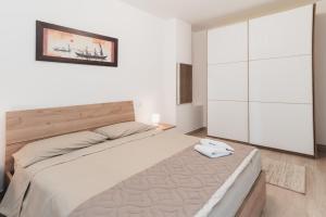 a bedroom with a large bed and a painting on the wall at Via Roma 34 in Castiglione del Lago