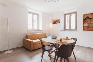 a living room with a table and chairs and a couch at Via Roma 34 in Castiglione del Lago