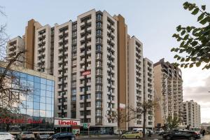 a large building with cars parked in a parking lot at Circ - 2 bedroom apartment in Staţia de Cale Ferată Visterniceni