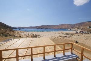 a wooden deck on a beach with a body of water at Ammoa Beach Residences in Vayiá +37 photos