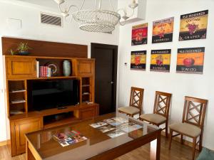 a living room with a table and a television at Suite El Alcázar in Carmona