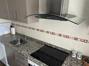 a kitchen with a sink and a stove at Suite El Alcázar in Carmona