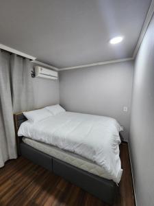 a small bed in a small room with a window at Suyu Station Motel in Seoul