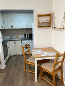 Una pequeña cocina con una mesa y dos sillas. en Apartment in residential complex with pool, en Klorakas