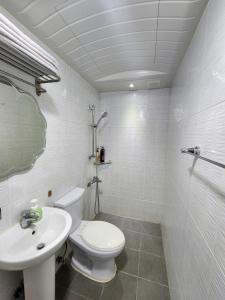 a white bathroom with a toilet and a sink at Suyu Station Motel in Seoul