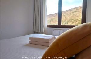 una camera da letto con un letto con due asciugamani sopra di AC Apartaments Centre a Pas de la Casa