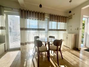 a dining room with a table and chairs and windows at Blue Sky Villa in Brca