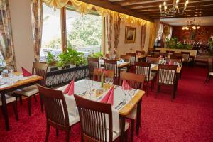 a dining room with tables and chairs with pink napkins at Hotel-Gasthof Die Post Brennerei Frankenhöhe in Schillingsfürst