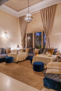 un soggiorno con divani, tavoli e lampadario a braccio di Kenzi Menara Palace & Resort a Marrakech