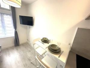 ein Wohnzimmer mit einem Tisch mit Tellern darauf in der Unterkunft Résidence Champenoise 3, Troyes - France in Troyes