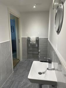 a white bathroom with a sink and a mirror at 1 bed spacious flat in Essex in Brentwood