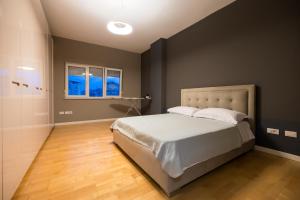 a bedroom with a large bed with a black wall at Tirana Center Luxury Landing in Tirana