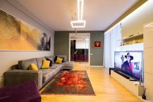 a living room with a couch and a flat screen tv at Tirana Center Luxury Landing in Tirana