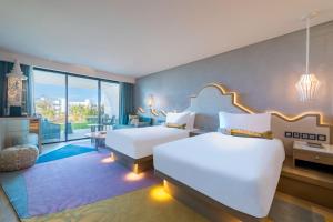 a hotel room with two beds and a balcony at W Algarve in Albufeira