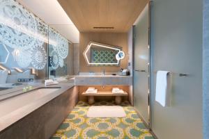 a bathroom with a tub and a sink at W Algarve in Albufeira