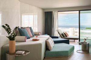 a bedroom with a large bed and a living room at W Algarve in Albufeira