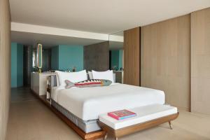 a bedroom with a large white bed and a table at W Algarve in Albufeira