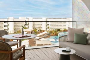 a balcony with a couch and tables and a pool at W Algarve in Albufeira
