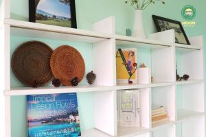 a white book shelf with books and baskets at Midori Heritage Coffee Farm in Da Lat