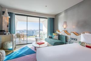a hotel room with a large bed and a balcony at W Algarve in Albufeira