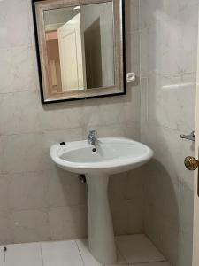 a bathroom with a white sink and a mirror at Studio 110 in Luanda +6 photos